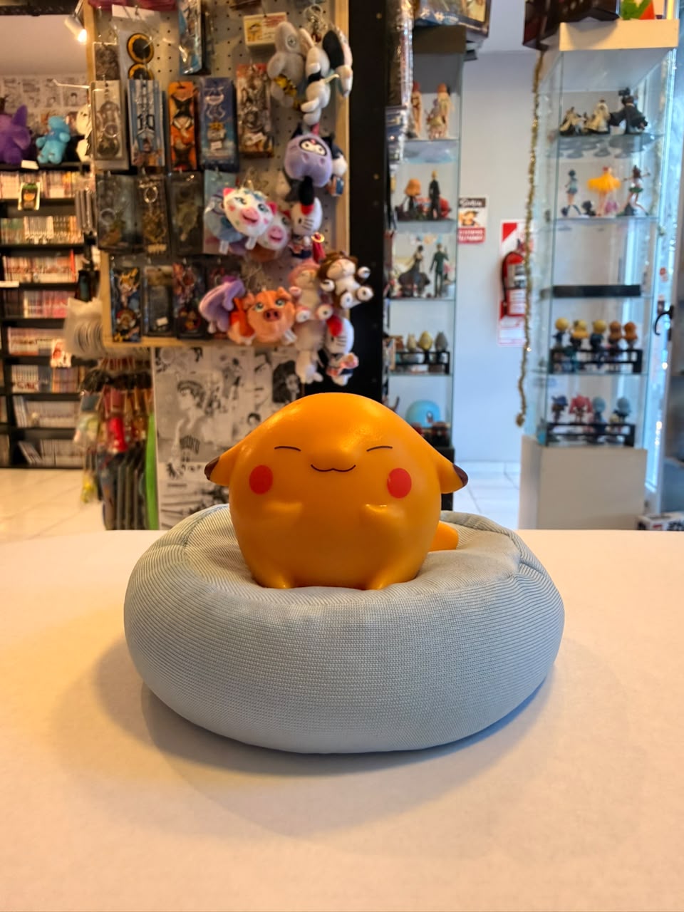 FIGURA GASHAPON DE PIKACHU OJOS CERRADOS DURMIENDO SOBRE COJIN AZUL