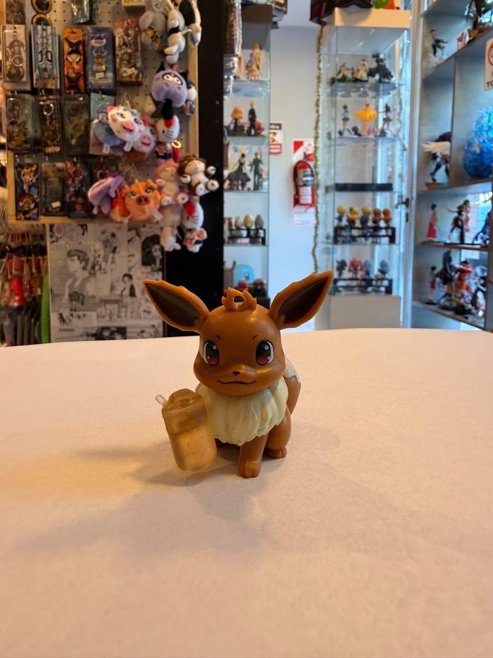 FIGURA GASHAPON DE EEVEE SOSTENIENDO BEBIDA