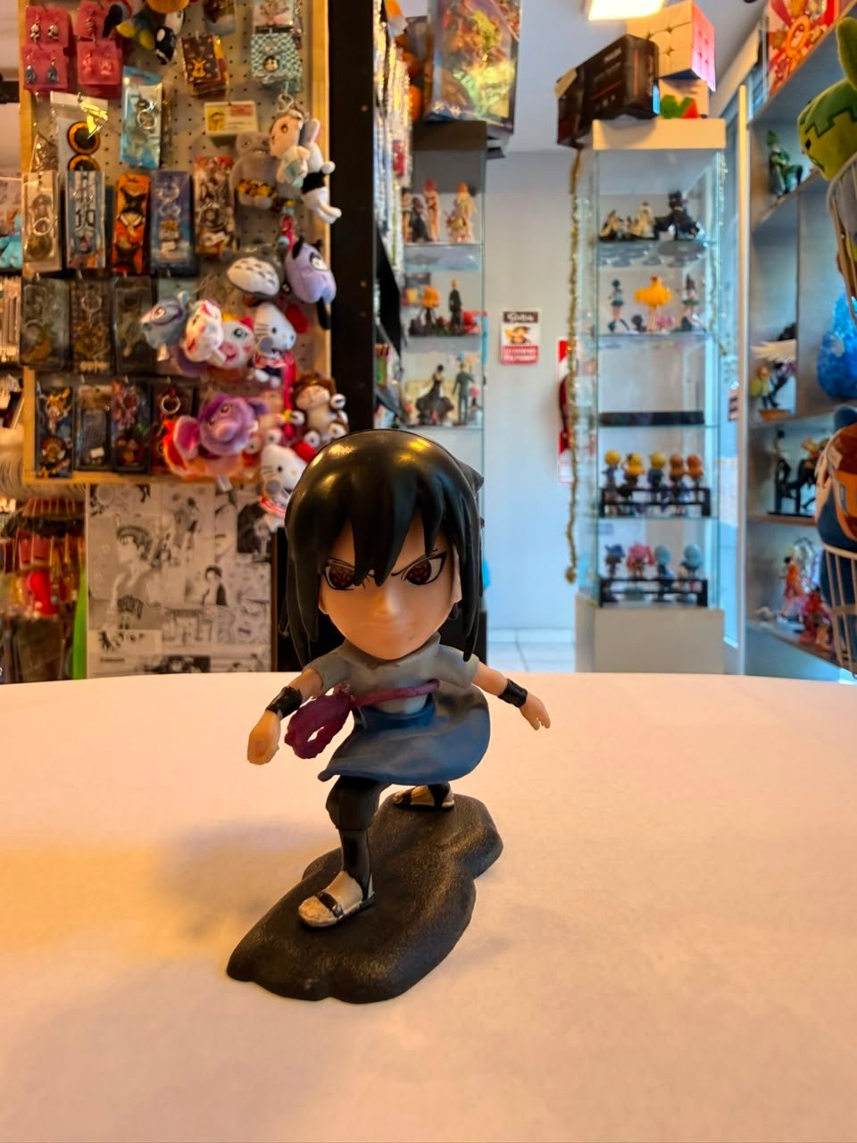FIGURA GASHAPON DE SASUKE SUJETA POR UN CINTURON DE CUERDA MORADA