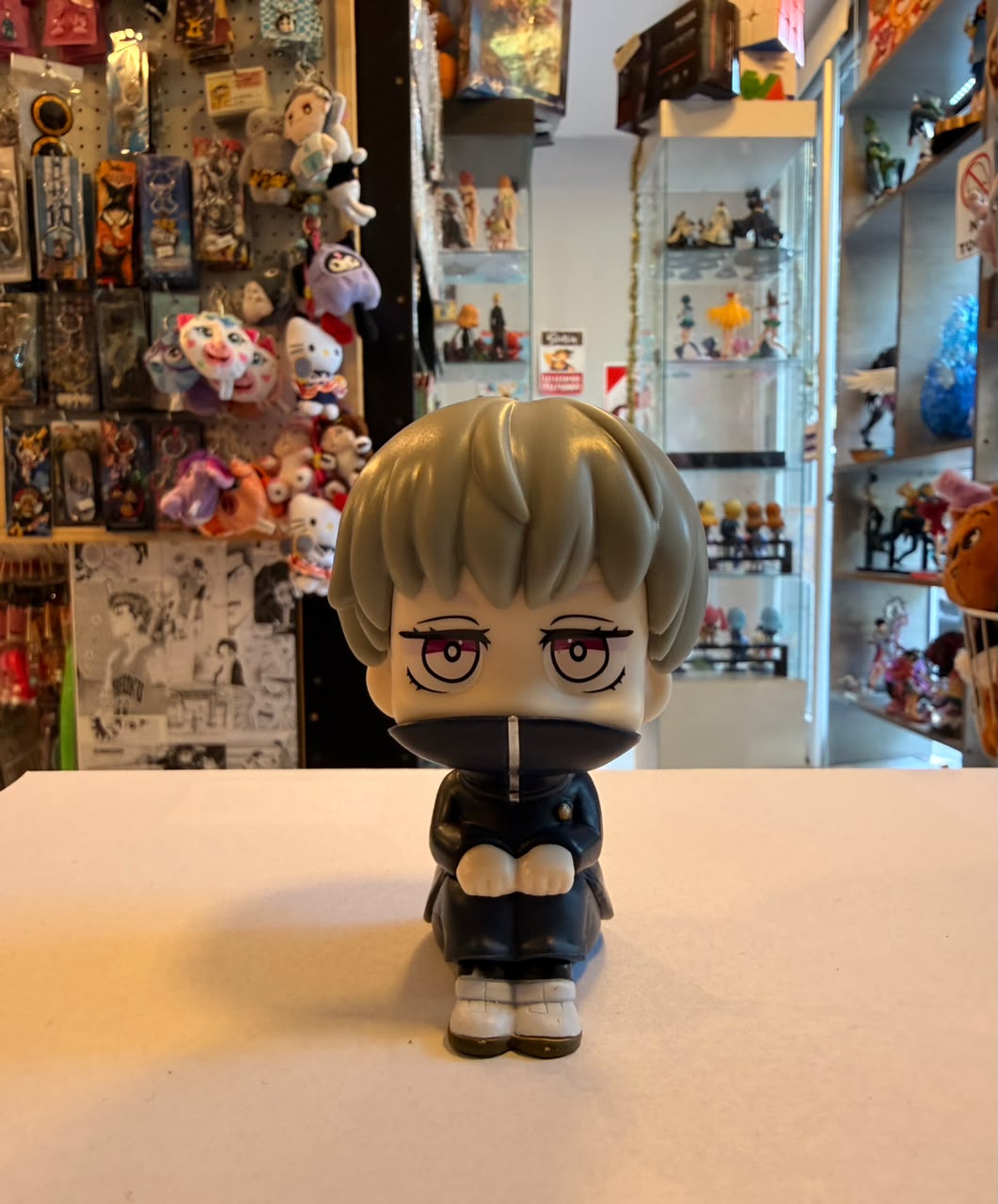 FIGURA DE TOGE SENTADO CON UNIFORME Y CUELLO ALTO LEVANTADO