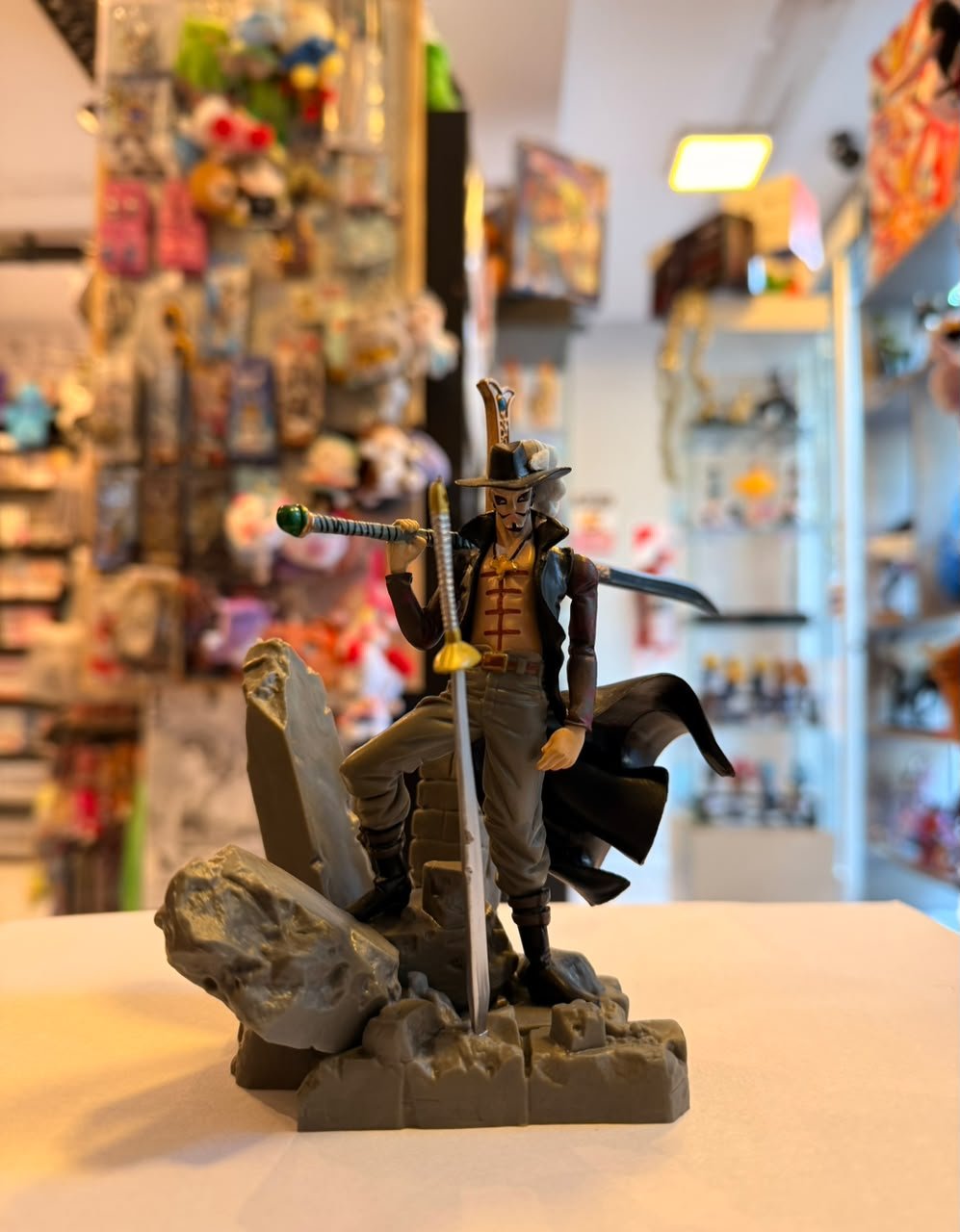FIGURA DE DRACULE MIHAWK CON SU ESPADA KOKUTO YORU, POSANDO SOBRE ROCAS