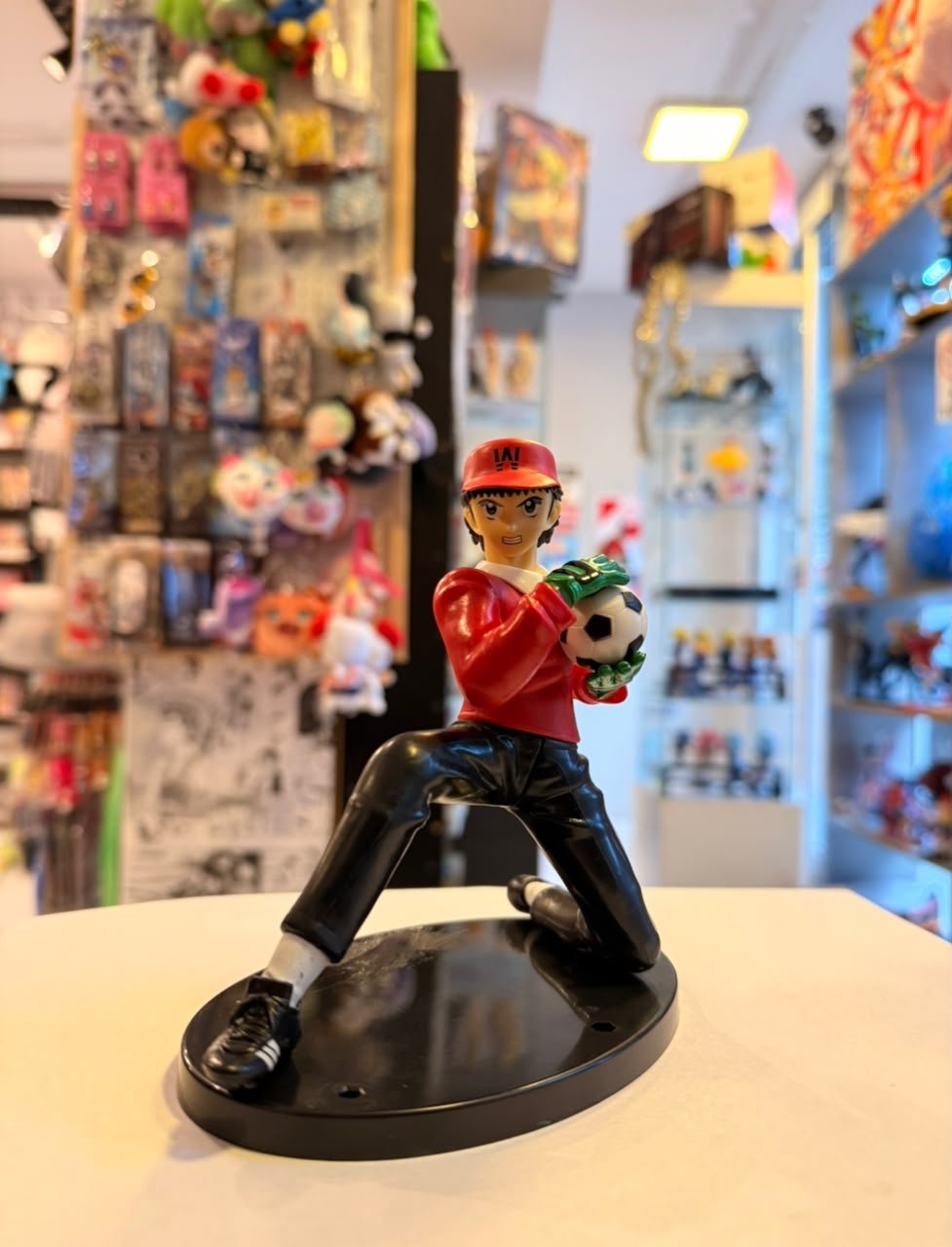 FIGURA DE BENJI PRICE ARRODILLADO SOSTENIENDO BALON DE FUTBOL
