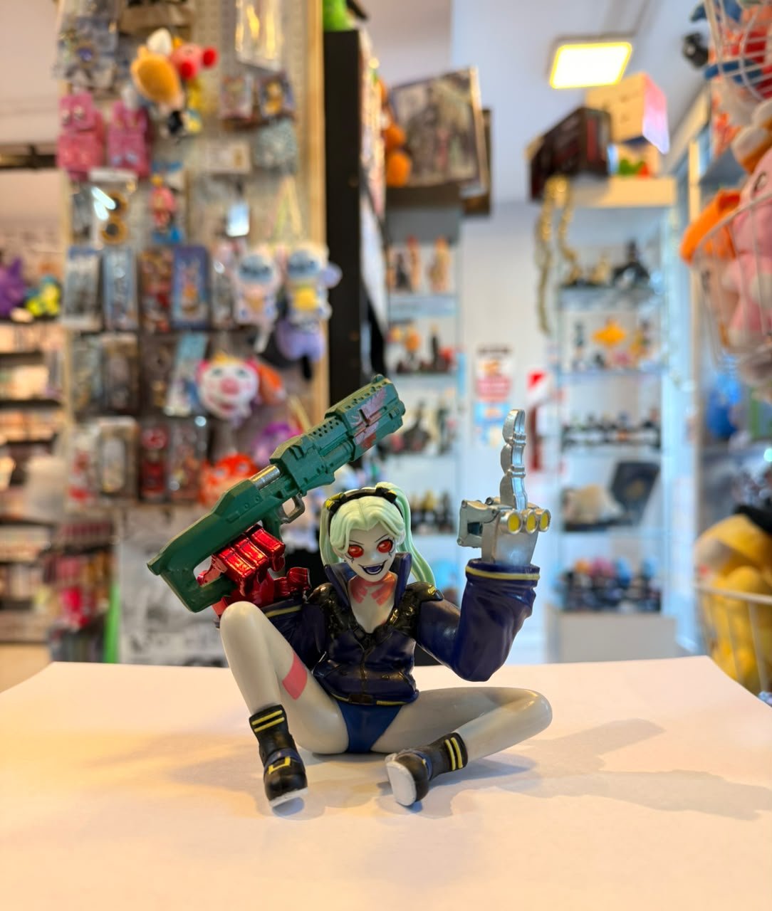 FIGURA DE REBECCA SENTADA Y SOSTENIENDO UN ARMA GRANDE