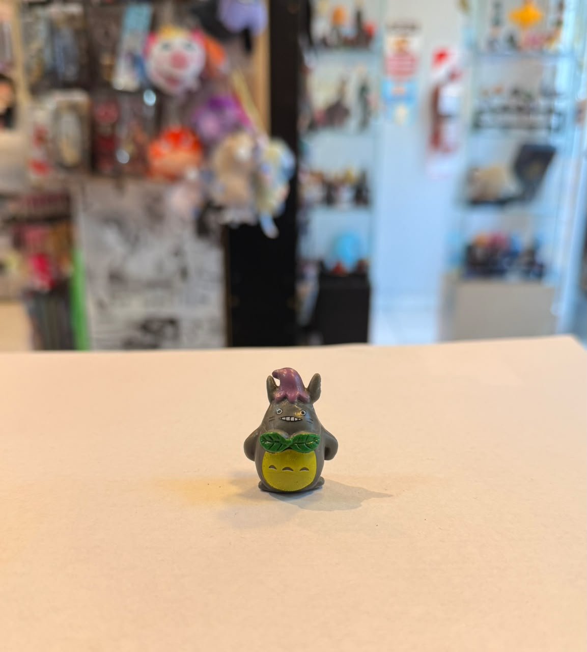 FIGURA GASHAPON DE TOTORO CON UNA HOJA EN EL PECHO Y GORRITO MORADO